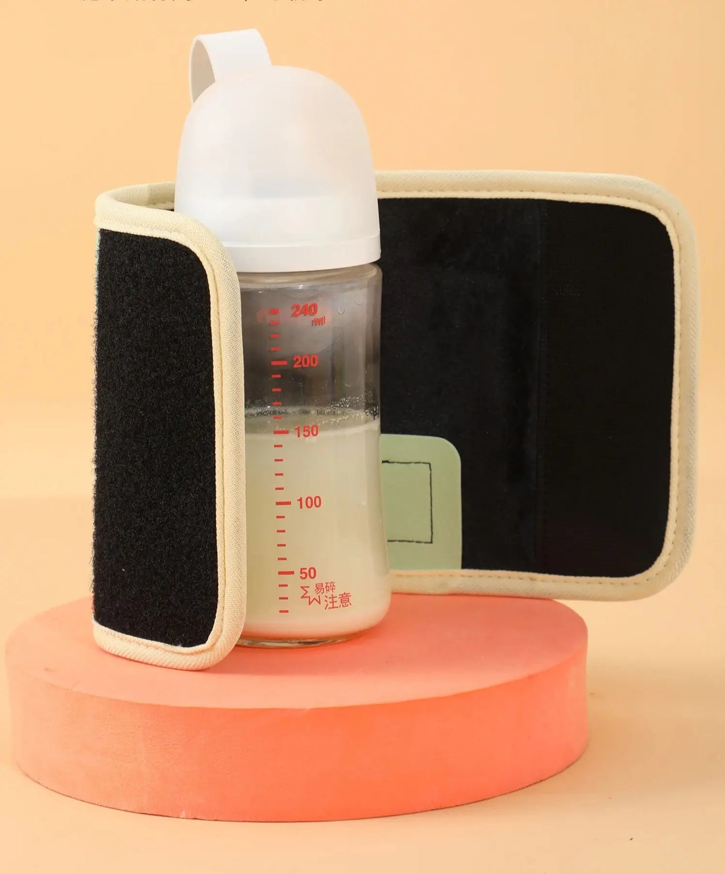 Black portable USB bottle warmer wrap with a white baby bottle filled with milk.