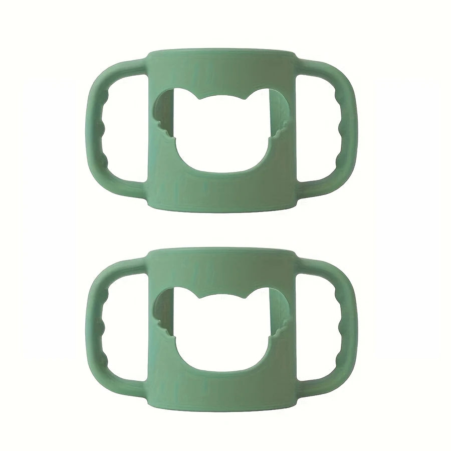 Two soft green silicone baby bottle handles with a cat-shaped cutout, designed for easy grip.