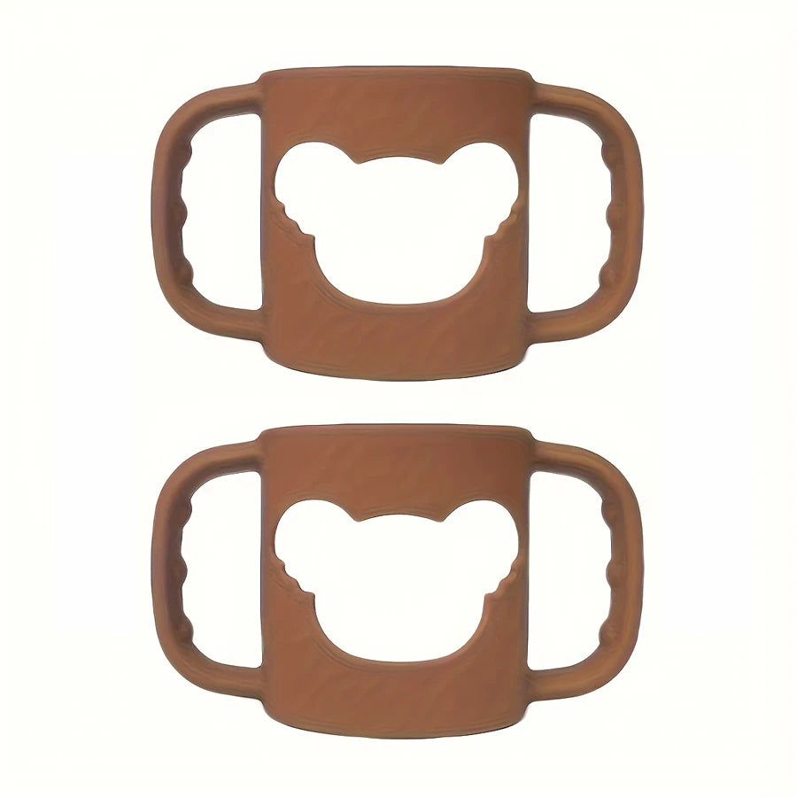 Two soft brown silicone baby bottle handles with bear-shaped cutouts, designed for easy grip.